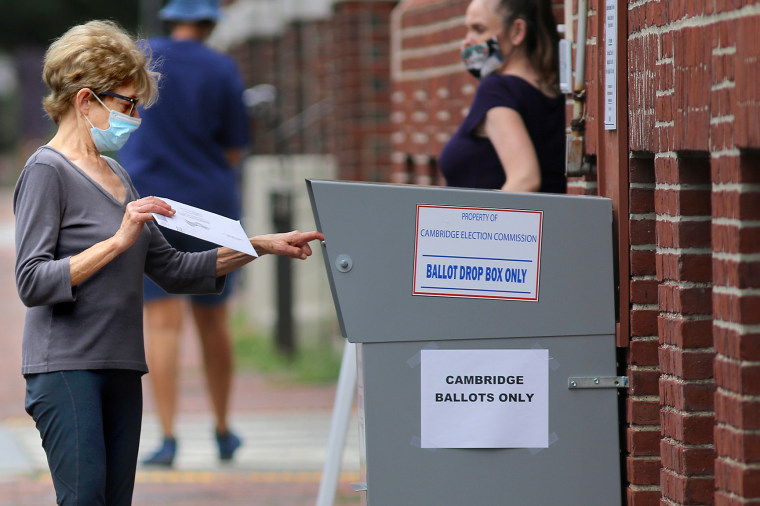 Image: A voter drops off a mail-in ballot in a collection box in Cambridge, Mass., on Aug. 25, 2020.