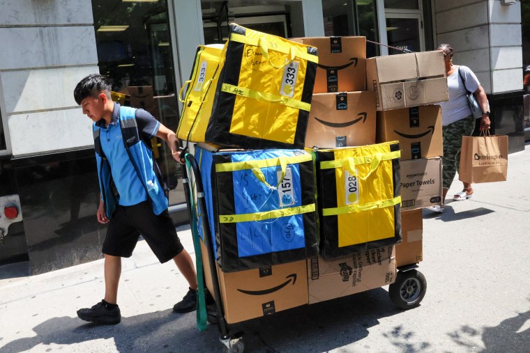 An Amazon worker pulls a cart of packages for delivery in New York City, on Amazon Prime Day, on July 12, 2022.