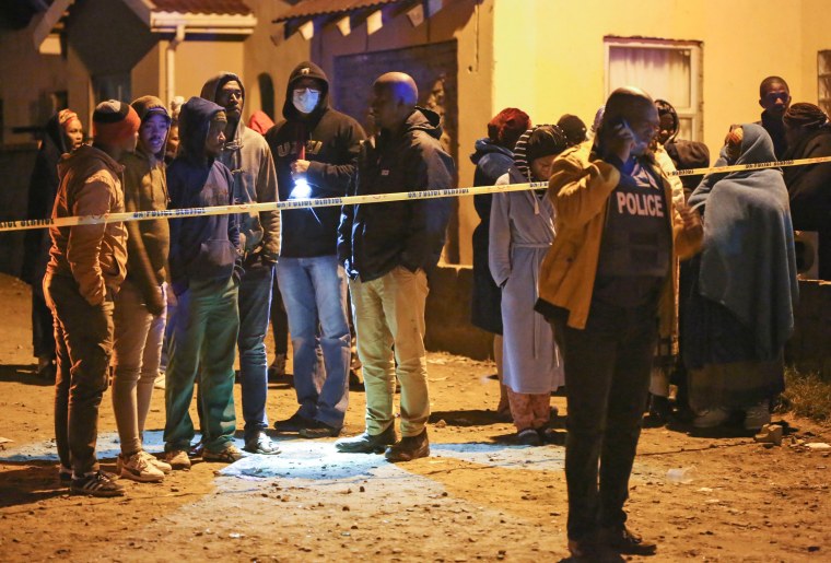 Members of the community wait for news outside a bar in East London, South Africa, on June 26, 2022.
