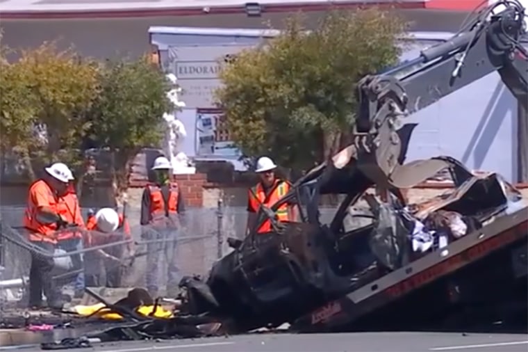 Crash investigators remove a destroyed car after an accident in Orange, Calif.
