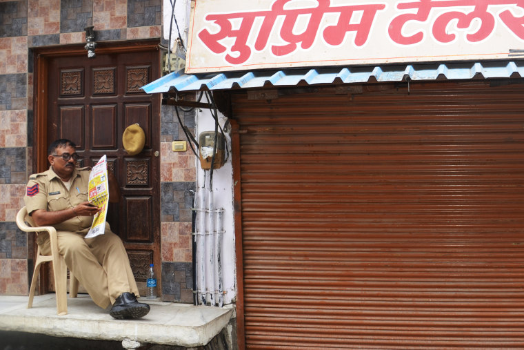 An officer guards Teli’s shop in Udaipur.