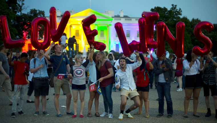 Same-sex marriage supporters hold up balloons that spell "love wins" in front of the White House, which is lit up in rainbow colors to celebrate the Supreme Court's ruling to legalize same-sex marriage, on June 26, 2015, in Washington.