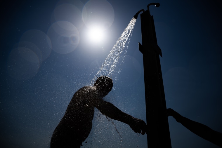 Image: A bather takes a shower at the Wannsee lido in Berlin on July 19, 2022.