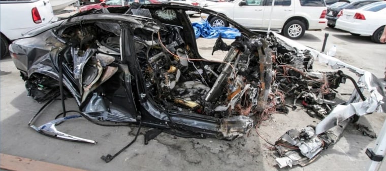 Right side of car, showing severe crash and fire damage from the 2018 crash of a Tesla Model S.