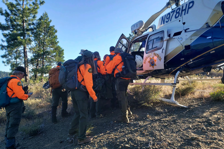 Members of the rescue team gather at a helicopter.