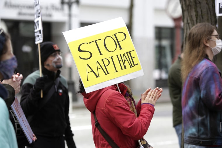 Image: A demonstrator holds a sign calling for a stop to hate against Asian Americans and Pacific Islanders (AAPI) during a national day of action against anti-Asian violence in Seattle on March 27, 2021.