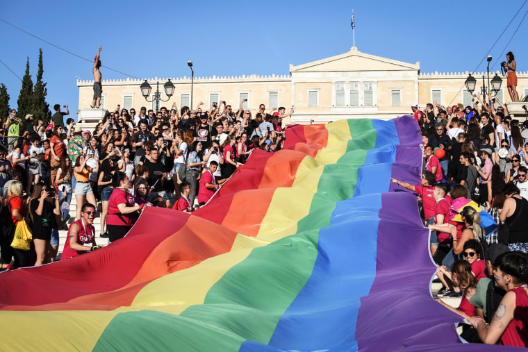 A pride flag is displayed in front of the Greek Parliament House