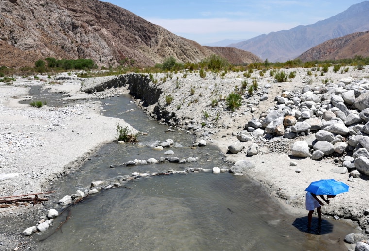 A child cools off underneath an umbrella at the Whitewater River