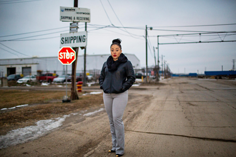 A woman stands near the entrance to the proposed new location of General Iron Industries plant