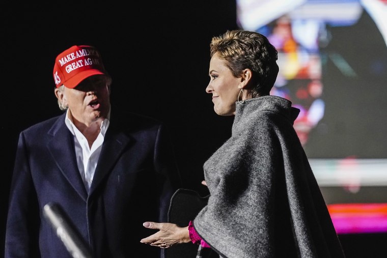 Former President Donald Trump, left, introduces Arizona Republican candidate for governor Kari Lake, right, as Trump speaks at a rally on Jan. 15, 2022, in Florence, Ariz.