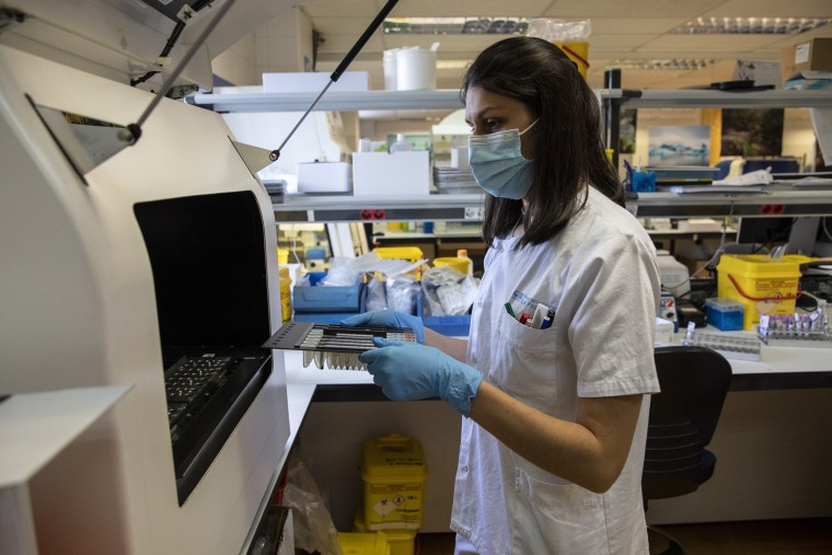 Image: A medical laboratory technician places suspected monkeypox samples inside an automated nucleic acid extractor before being PCR tested at the microbiology laboratory of La Paz Hospital on June 6, 2022 in Madrid.