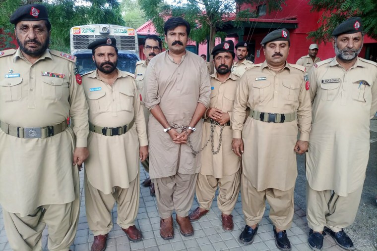 Police officers escort a man who was allegedly involved in raping an American woman in Dera Ghazi Khan, Pakistan. 