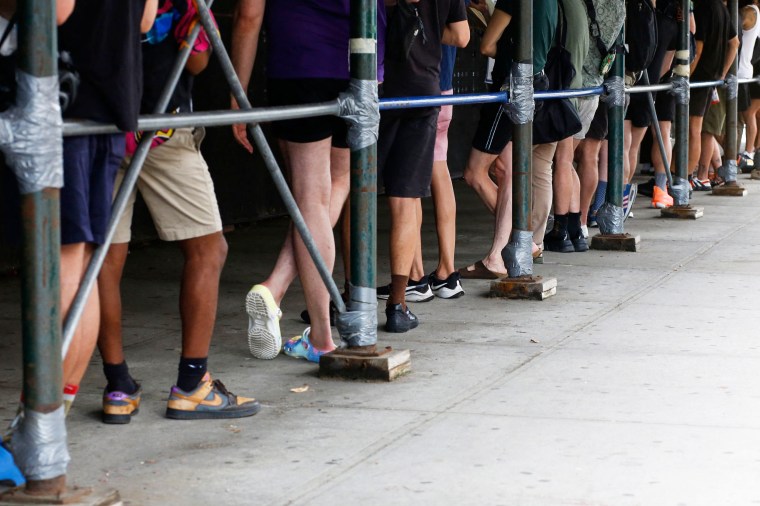 People wait in line to receive the monkeypox vaccine