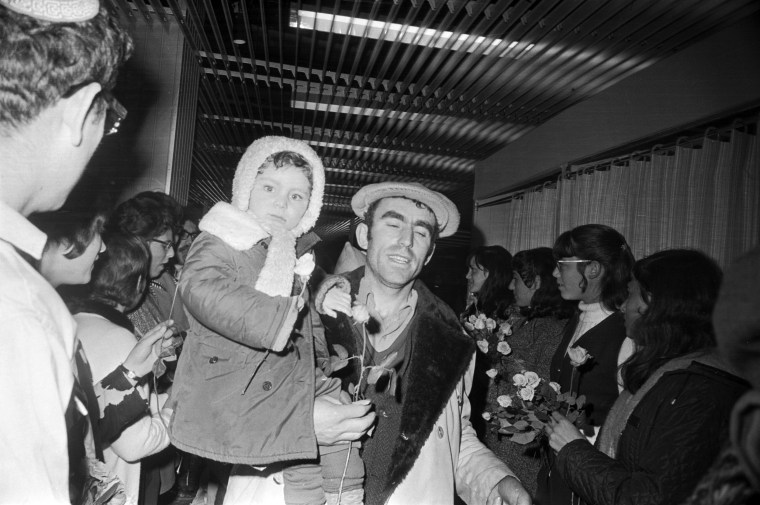 A welcoming committee presents Soviet Jews with flowers upon their arrival at Lod Airport on Jan 17, 1972, in Tel Aviv.   