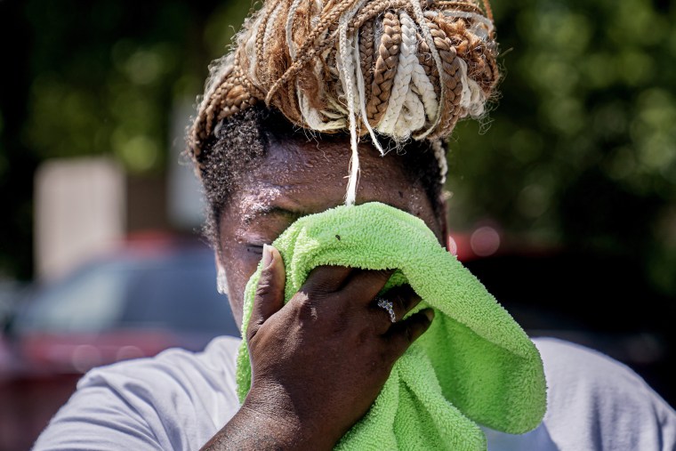 A woman wipes sweat from her face