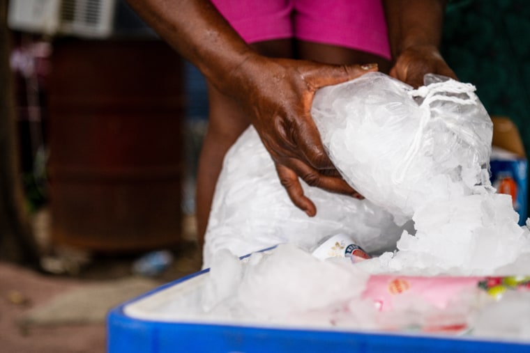 A woman fills an ice chest