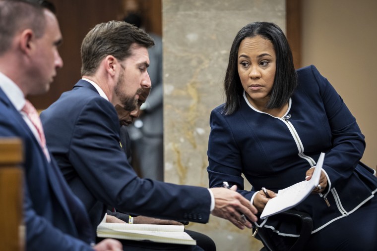 Fulton County District Attorney Fani Willis, right, talks with a member of her team during proceedings to seat a special purpose grand jury in Fulton County, Ga., on May 2, 2022.