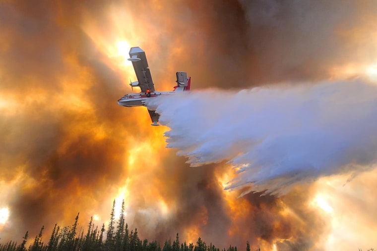 A fixed-wing aircraft drops water on the Clear Fire near Anderson, Alaska, on July 6. 