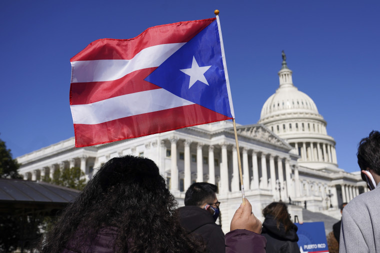 A woman waves the flag of Puerto Rico during a news conference on Puerto Rican statehood on Capitol Hill on March 2, 2021. 