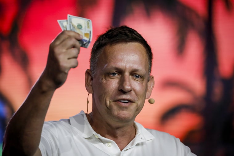Image: Peter Thiel holds hundred dollars bills during the Bitcoin 2022 conference in Miami, Fla.  on April 7, 2022.
