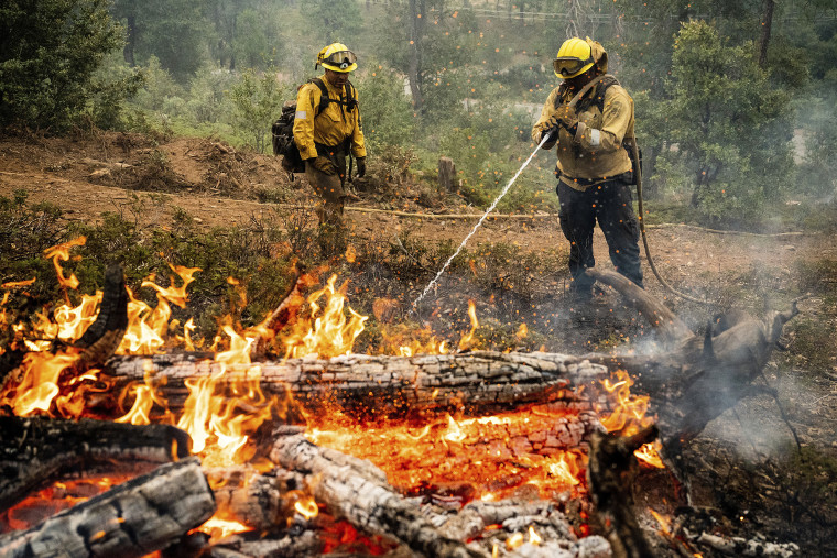 Firefighters mop up hot spots Monday while battling the Oak Fire in the Jerseydale community of Mariposa County, Calif.