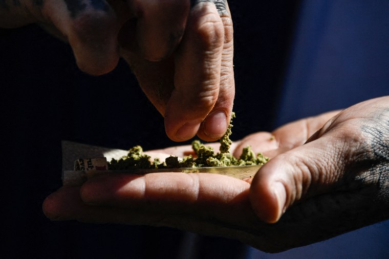 A person rolls a joint during the Mile High 420 Festival in Denver on April 20, 2022.
