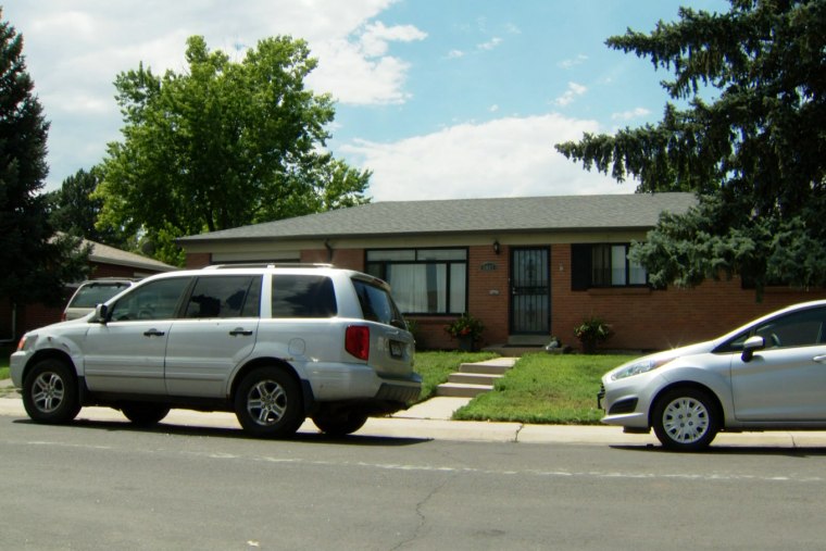 Cars parked outside the home where a man fired a gun at police, in Englewood, Colo.