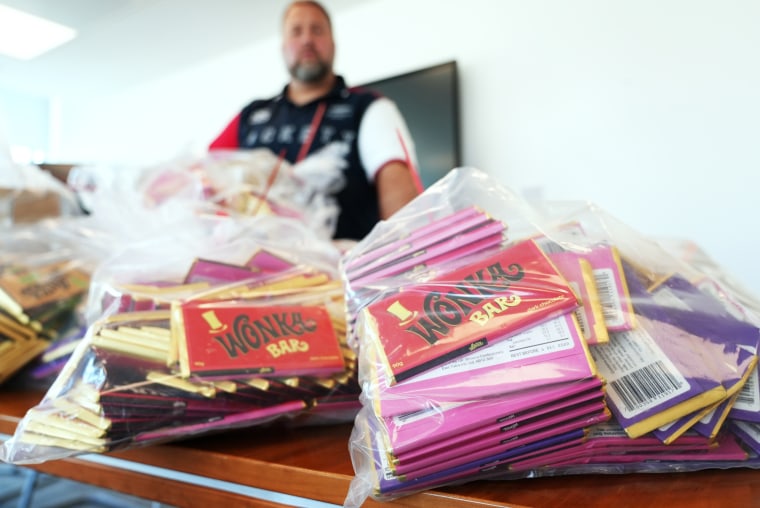 Loren Phillips, an officer with Westminster Council, stands over a haul of counterfeit Wonka bars seized on Oxford Street.