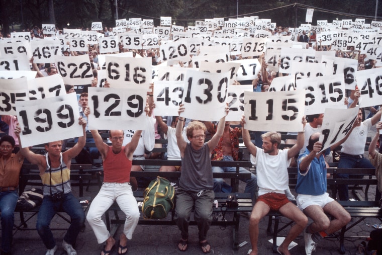 PICTURED: People hold up signs depicting the number of AIDS victims at a demonstration in support of AIDS victims in Central Park in New York City on August 8, 1983.