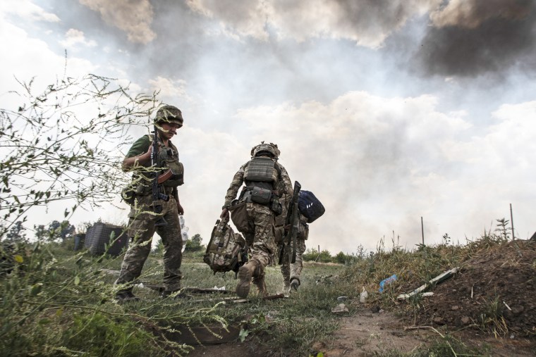 Paratroopers come out from a trench after a rocket attack