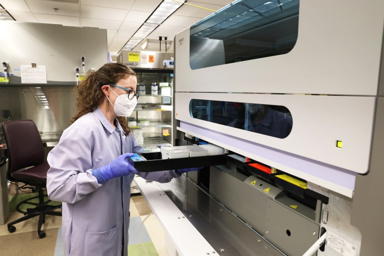 Image: Research Scientist Dr. Margaret Mills sets up an instrument that extracts DNA for Monkeypox virus testing at the UW Medicine Virology Laboratory on July 12, 2022 in Seattle.