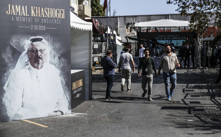 صورة: أشخاص يمررون ملصق بمناسبة الذكرى الأولى لوفاة الصحفي السعودي جمال خاشقجي في اسطنبول بتركيا في 2 أكتوبر / تشرين الأول 2019.