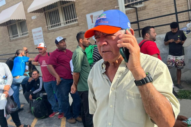 A 70-year-old Venezuelan migrant uses a cellphone as he waits in line to take a shower at a homeless center in San Antonio.  He says, "Let's see if they give me underwear, which I don't have."