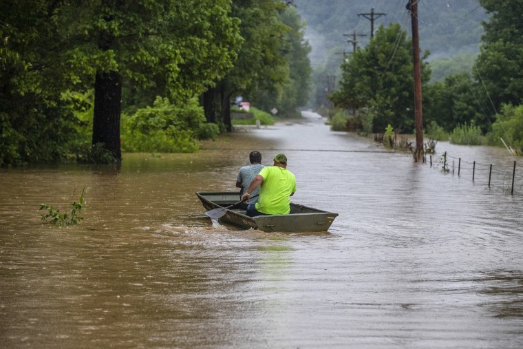 Men ride in a boat along flooded Wolverine Road in Breathitt County, Ky., on July 28, 2022.