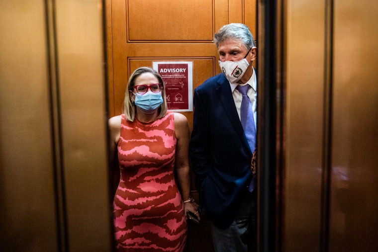 Sens. Kyrsten Sinema, D-Ariz., and Joe Manchin, D-W.Va., take the elevator at the Capitol on Sept. 30, 2021.