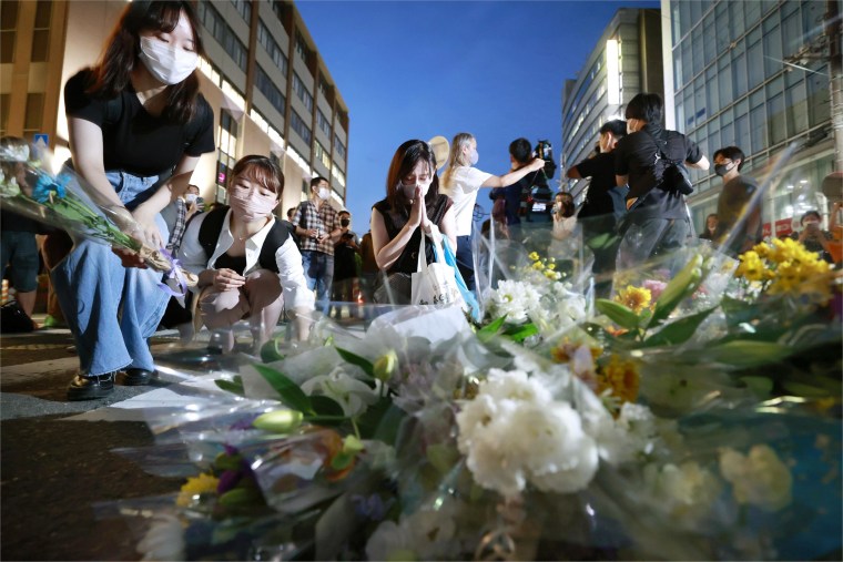 People pray and pay their respects at a makeshift memorial where the former Prime Minister Shinzo Abe was shot and killed. 