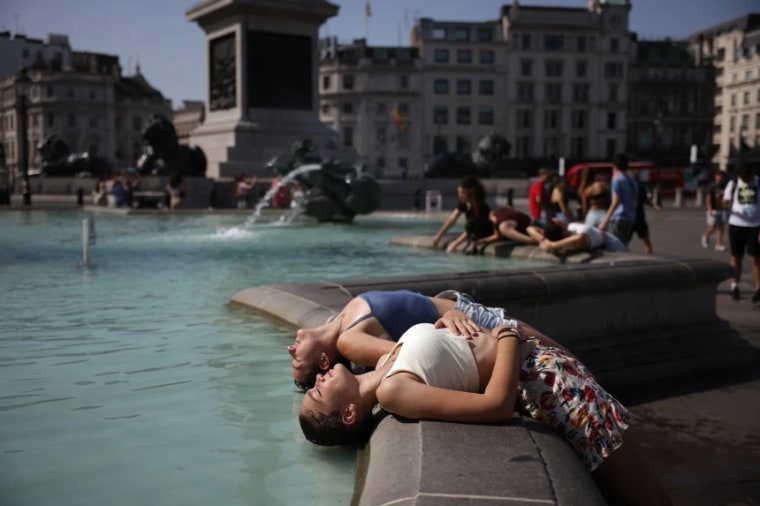 Dos mujeres sumergen su cabeza en una fuente de Londres para combatir el calor.