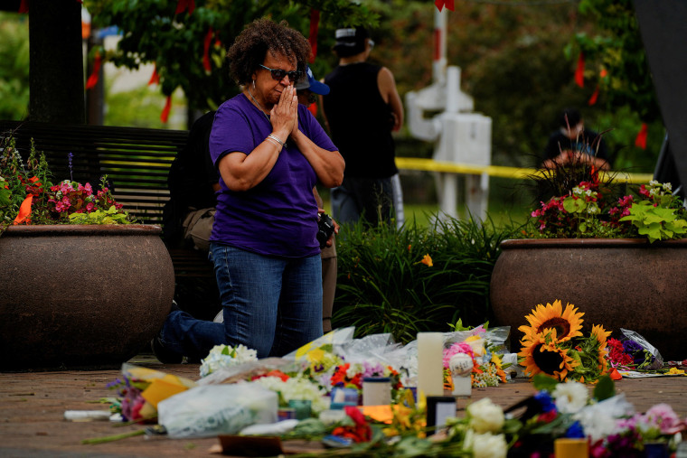 Una mujer reza en un sitio conmemorativo armado tras el tiroteo masivo en el suburbio de Chicago de Highland Park, Illinois.