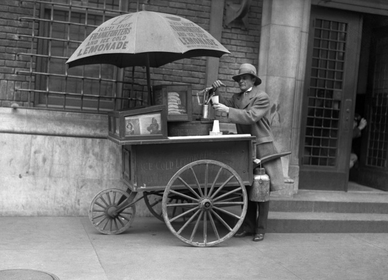 A Lemonade and Hot Dog Vendor in a Street in N.Y.C.