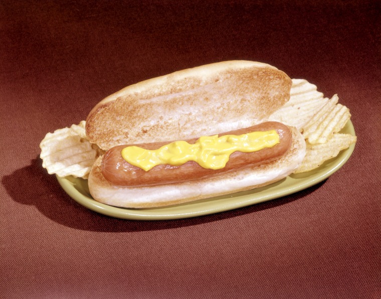 A 1960s hot dog on a toasted bun with mustard and chips.