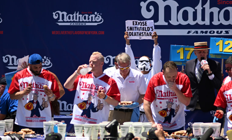 A protester interrupts defending champion Joey Chestnut competing in the famous Nathans 2022 July 4th International Hot Dog Eating Contest in Coney Island on July 4, 2022.