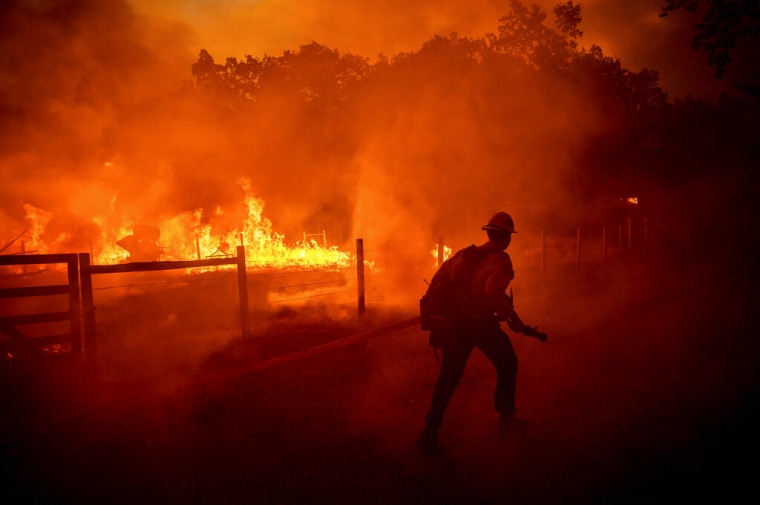 Un bombero corre para extinguir las llamas mientras el Oak Fire cruza Darrah Rd. en el condado de Mariposa, California, el viernes 22 de julio de 2022.