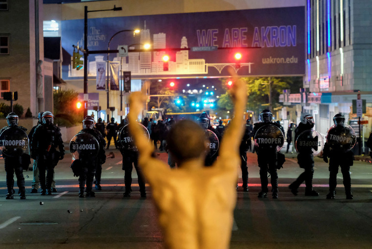 Un hombre hace un gesto hacia los oficiales con equipo antidisturbios en una protesta por el asesinato de Jayland Walker en la cual la policía desplegó gases lacrimógenos y granadas de aturdimiento, el 3 de julio de 2022.