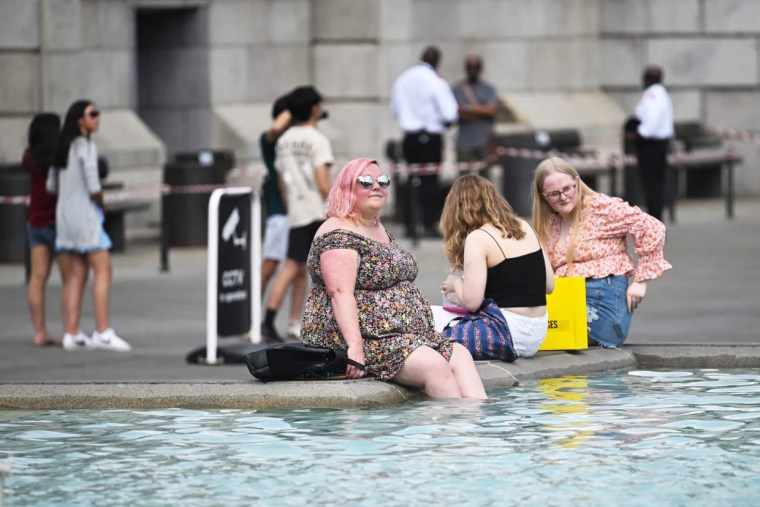 Unas personas se refrescaban sumergiendo sus pies en la fuente de Trafalgar Square, en Londres, durante la ola de calor que se experimentó el 13 de julio.