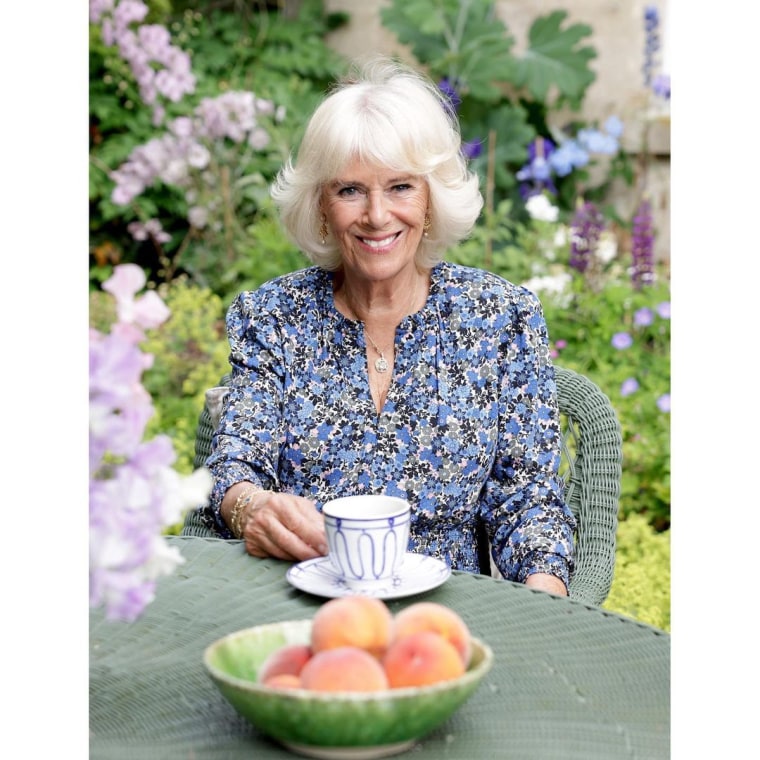 Camilla poses with a bowl of peaches.