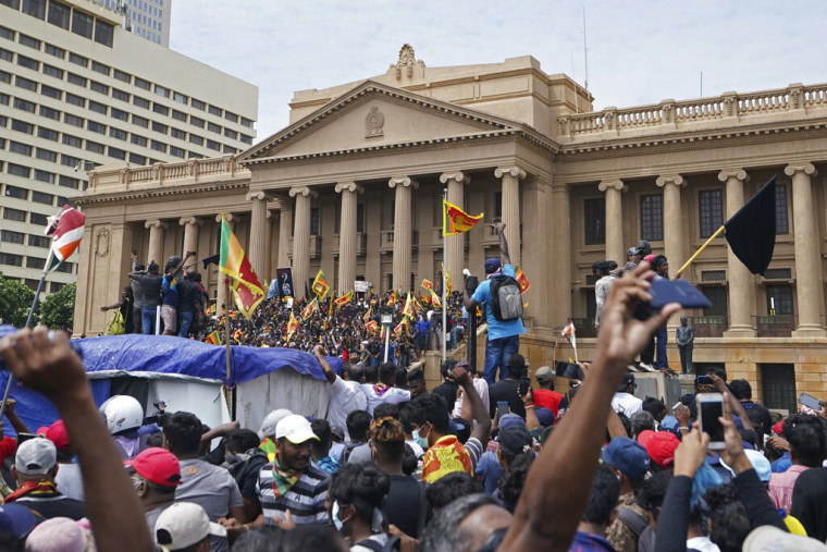 Manifestantes, muchos con banderas de Sri Lanka, se reúnen en torno a la oficina del presidente en Colombo, Sri Lanka, el sábado 9 de julio de 2022.