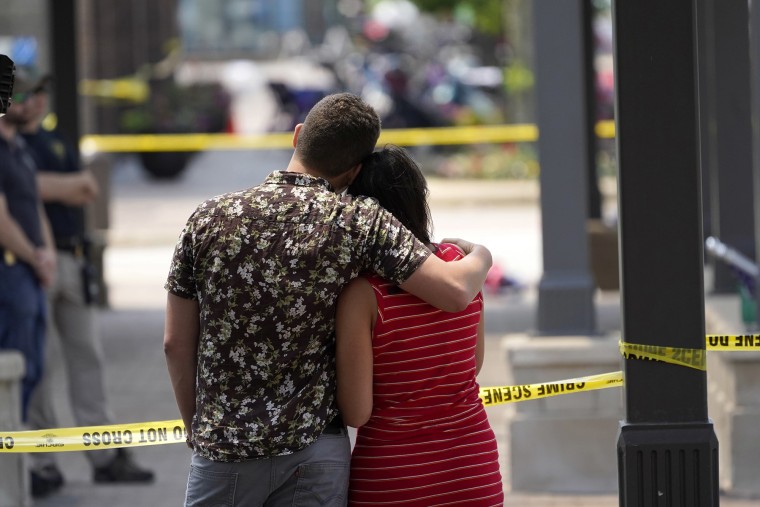 Una pareja mira hacia la escena del tiroteo del 4 de julio en el centro de Highland Park, un suburbio de Chicago, Illinois.