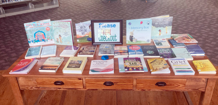 A photograph of a table set up to showcase books on grief, healing and life after loss.