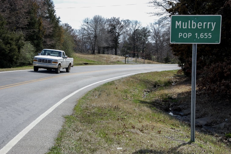 A truck drives near a population sign in Mulberry, Ark., on March 13, 2013.