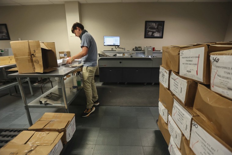 An ATF worker prepares gun sale documents before they are scanned.